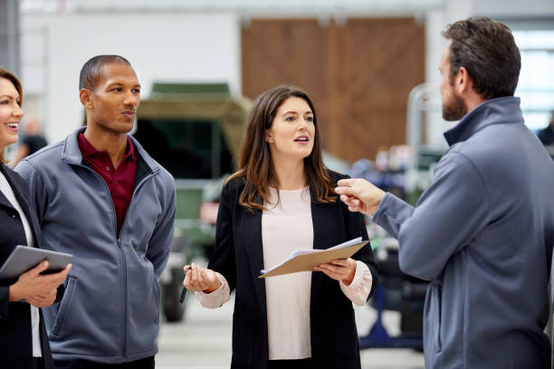 istock Manager discussing with engineer in car factory 916868918