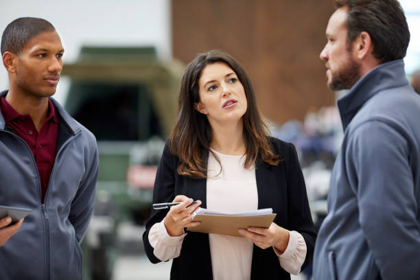 istock Inspector discussing with engineer in car factory 916868930
