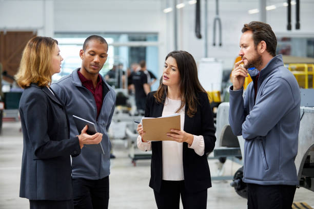 istock Manager discussing with colleagues in car factory 916868938