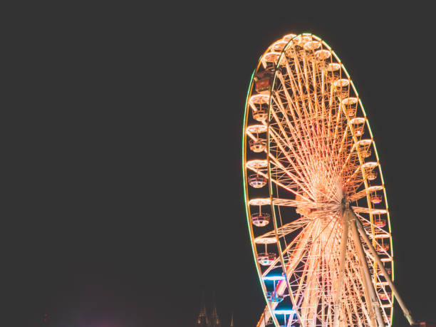 istock Big Wheel on a fun fair at night with Cologne Cathedral in background 916871478
