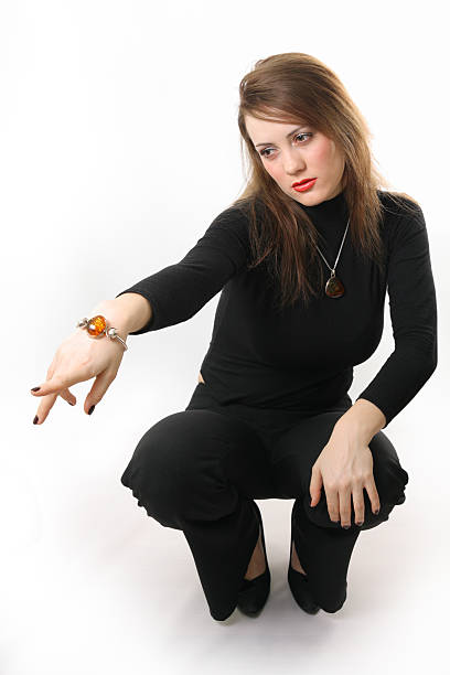 Close up of a young smiling woman making the Namaste gesture, practicing yoga, working out, wearing sportswear, blue suit and chain pearl wrist bracelets, indoor, white loft studio background