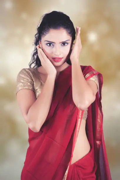 Beautiful Indian woman wearing Saree over blurred background