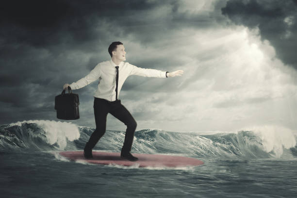 istock businessman surfing on a cloudy day 916874212