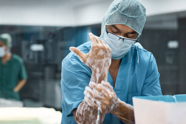 veterinario hombre lavarse las manos con jabón - scrubbing up fotografías e imágenes de stock