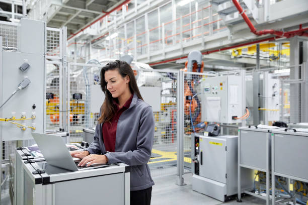 istock Female engineer using laptop in car factory 916875482