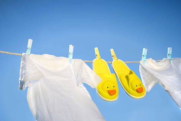 White t-shirts and slippers on the clothesline stock photo