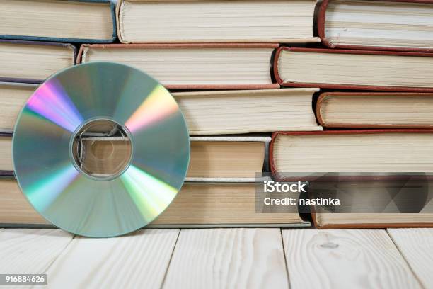 Pile Of Old Books Stacked On Top Of Each Other With A Compact Disc Stock Photo - Download Image Now