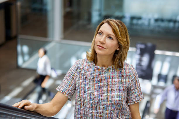 istock Thoughtful businesswoman looking away on escalator 916885474