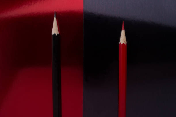 istock Red and black colored pencils isolated on a red and black background 916890210