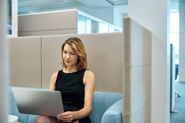 istock Businessman using laptop in office cubicle 916890568