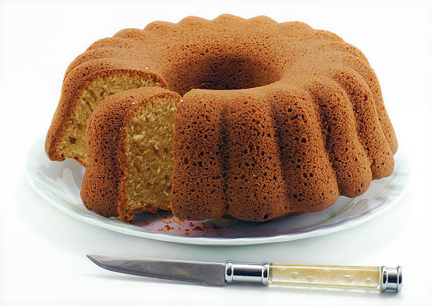 Knife cutting a bundt cake on a white plate stock photo