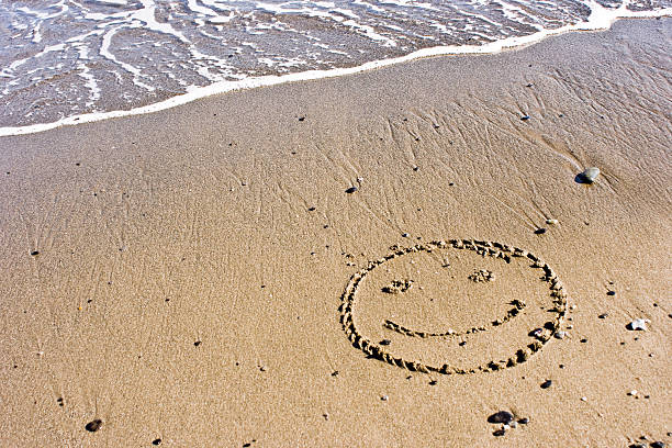 istock A smile drawn on a shoreline of a beach 91689455