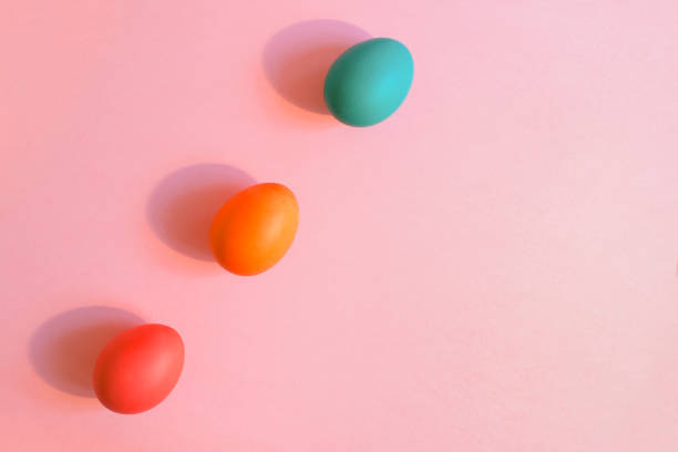 istock Flat lay three Easter colorful eggs are lying diagonally on a pink background with copy space. 916895664