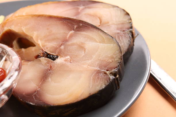 Close-up slices of smoked fish on the plate stock photo