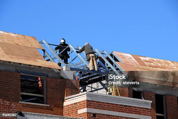 Foto de Trabalhadores De Construção Na Cobertura e mais fotos de stock de Inverno - Inverno, Trabalhador de Construção, Armação de Construção