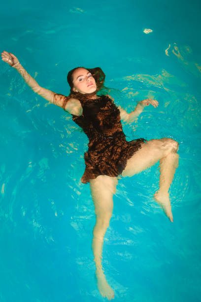 istock Woman floating relaxing in swimming pool water. 916904076