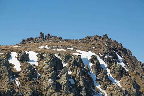 istock Rocks with snow against the sky 916906522