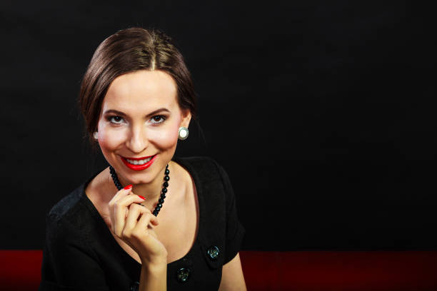 Portrait of a glamorous, well dressed woman with dark, film noir lighting. Cut out.