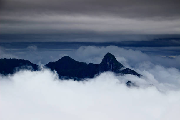 istock Dark sharp peaks rise above the clouds in Carnic Alps Italy 916910528