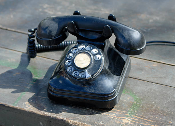 Old fashion telephone Old black telephone on old wooden table. (see some similar pictures clicking the images-classic style) alexander graham bell stock pictures, royalty-free photos & images