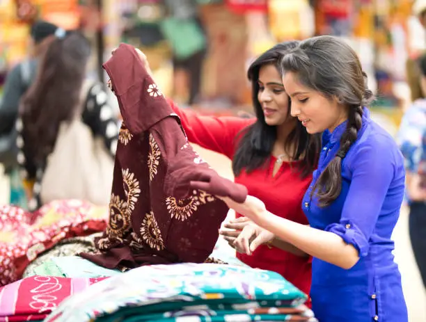 Women shopping for dress at street market