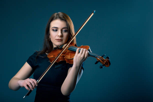 istock Woman with violin on blue grey background 916924552