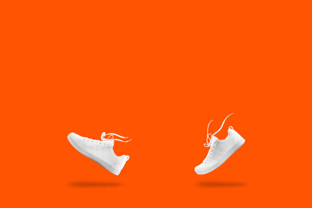 Pair of White sneaker composition like walking and floating rope isolated on orang background with clipping path Modern touch screen smartphone isolated on white background with clipping path someone walking sneakers stock pictures, royalty-free photos & images