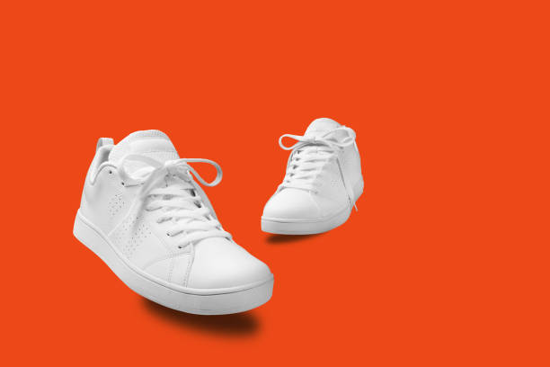 istock Pair of White sneaker isolated on orange background with clipping path 916925030