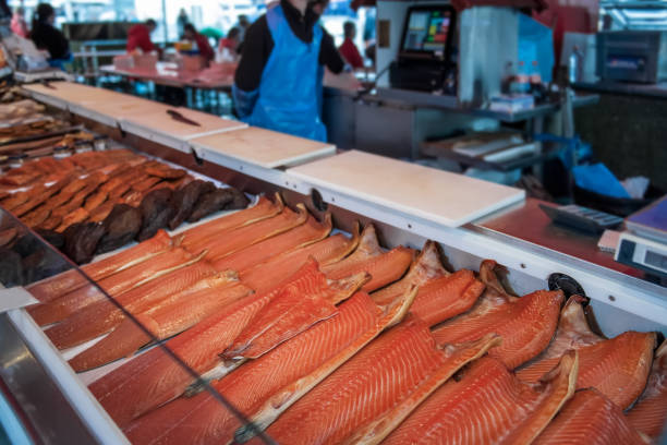 Large showcase with halves of delicious fish of the North sea trout, salmon, pink salmon on the counter in the Norwegian fish market. Copy space. stock photo