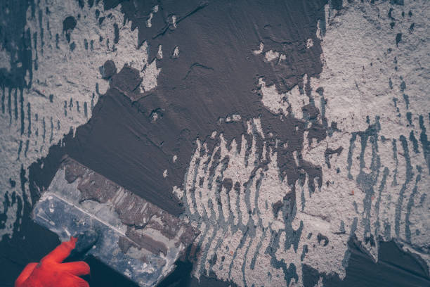 istock The worker aligns the wall with a tile adhesive applying it with a spatula, preparation for tiling 916930848