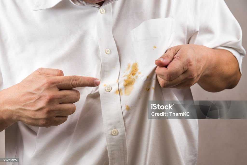 Personne en pointant sur la tache de curry déversé sur chemise blanche. - Photo de Taché libre de droits