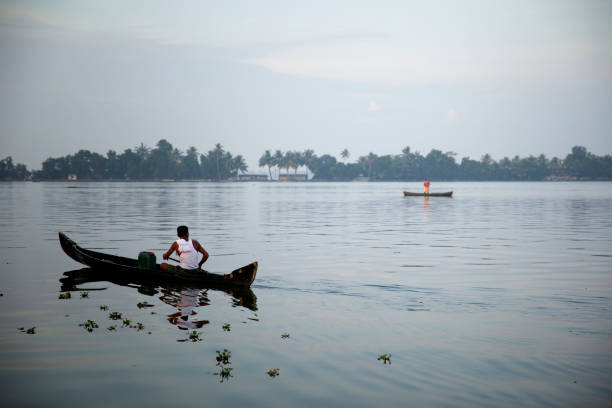 Early morning in Kerala Backwater. South India. Older man sailing out to fish.