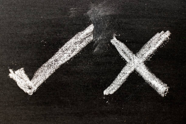 istock White color chalk hand drawing as check mark of right and wrong shape on black board background 916935288