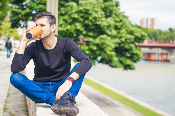 istock man sitting near the city river relaxing 916935384