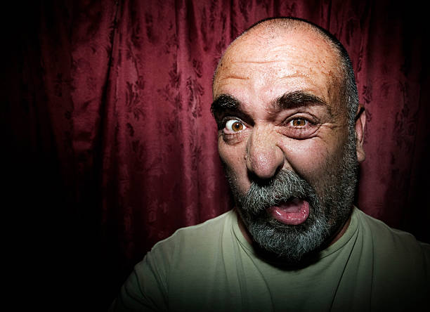 istock Man making a funny face in front of red curtains 91693550