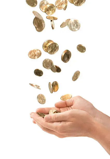 Gold coins falling into a pair of cupped male hands isolated over white. Photograph was composed of several shots, cleaned up in Photoshop and composed together. Canon 5D.