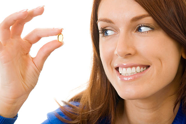 Young happy woman with Omega 3 fish oil capsule, isolated stock photo