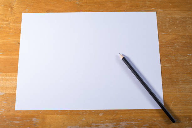 istock White paper with black pencil  on wood table 916941194