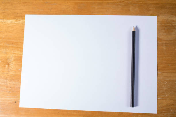 istock White paper with black pencil  on wood table 916941280