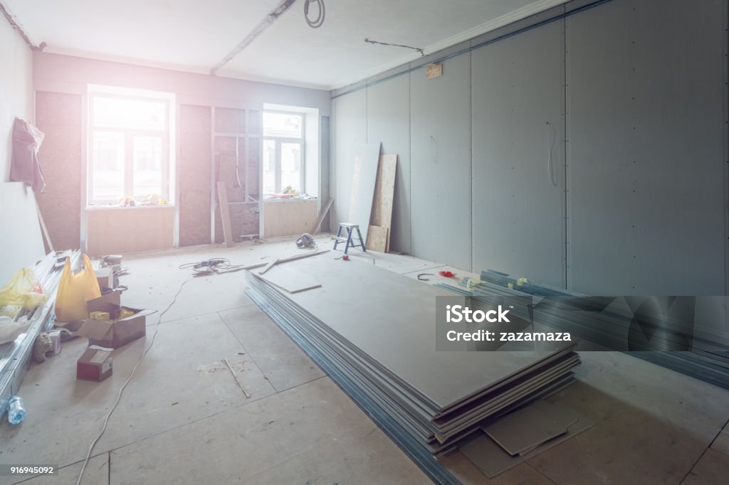 Working process of installing metal frames for plasterboard (drywall) for making gypsum walls  in apartment is under construction, remodeling, renovation, extension, restoration and reconstruction. Restoring Stock Photo