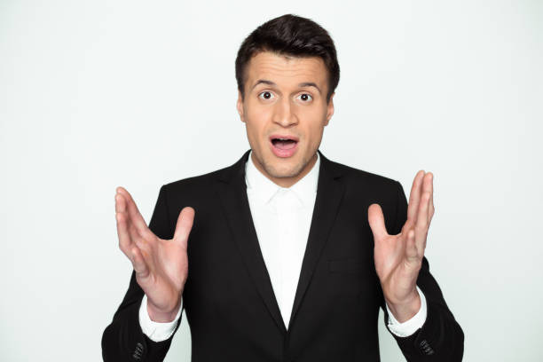 istock Wow! A young man in a black jacket with a surprised expression on his face looks into the camera. 916945570