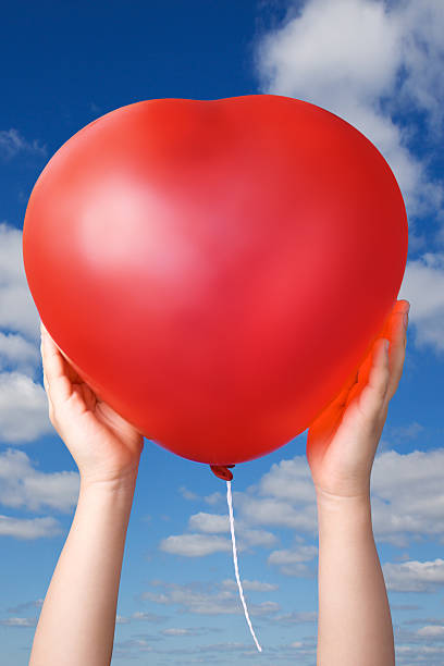 Red balloon in child hands stock photo