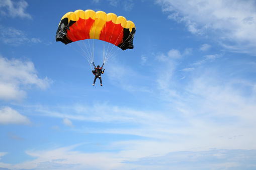 A man with parachute flying in the sky