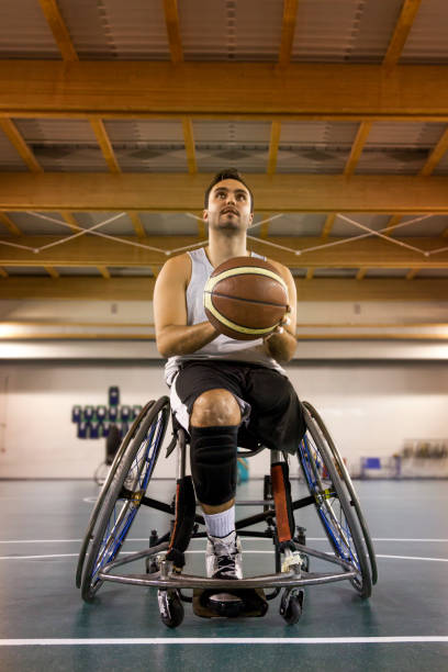 disabled sport men in action while playing indoor basketball stock photo