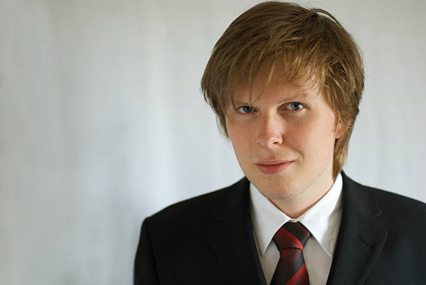 young business man smiling on light background stock photo