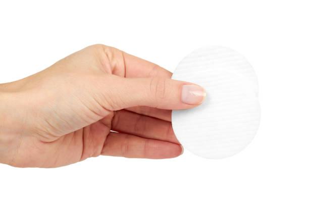 istock Round cotton pads in hand, isolated on white background 916962438