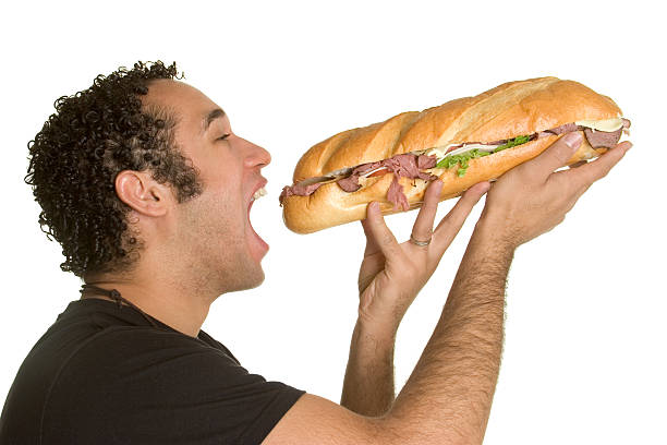 Hombre su apetito con un sándwich - foto de stock