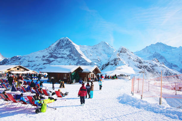 гора маннлихен и курорт с туристами в зимних швейцарских альпах - jungfrau eiger monch bernese oberland стоковые фото и изображения