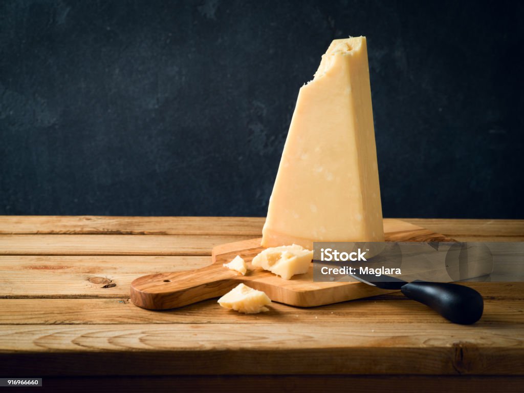 Parmesan cheese on wooden table Parmesan cheese on wooden table over black stone background Parmesan Cheese Stock Photo