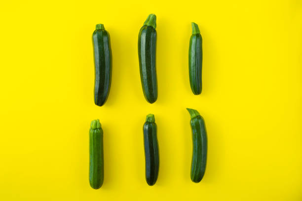 zucchini on yellow background, minimal, fresh vegetables, creative composition